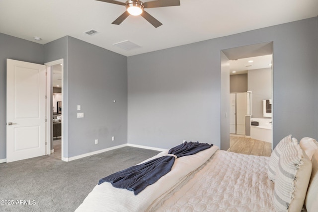 carpeted bedroom featuring visible vents, baseboards, ensuite bath, and a ceiling fan