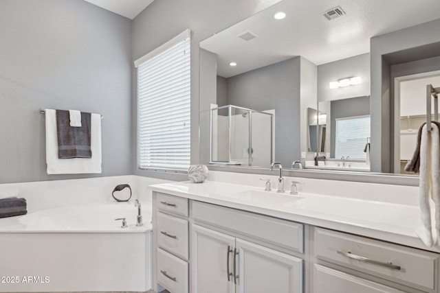 bathroom with visible vents, a healthy amount of sunlight, a bath, and a shower stall