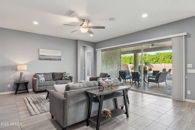 living area with light tile patterned floors, visible vents, baseboards, and a ceiling fan