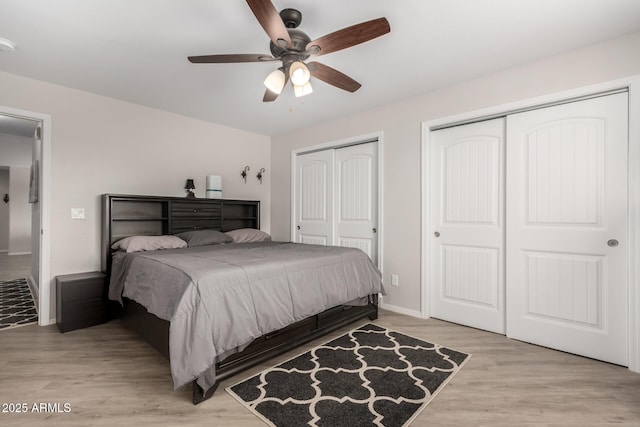 bedroom with multiple closets, light wood-style floors, baseboards, and a ceiling fan