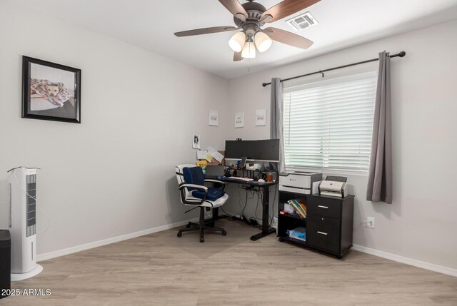 home office with wood finished floors, visible vents, and baseboards