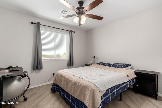 bedroom featuring a ceiling fan, light wood-type flooring, visible vents, and baseboards