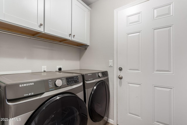 washroom with cabinet space and washing machine and clothes dryer