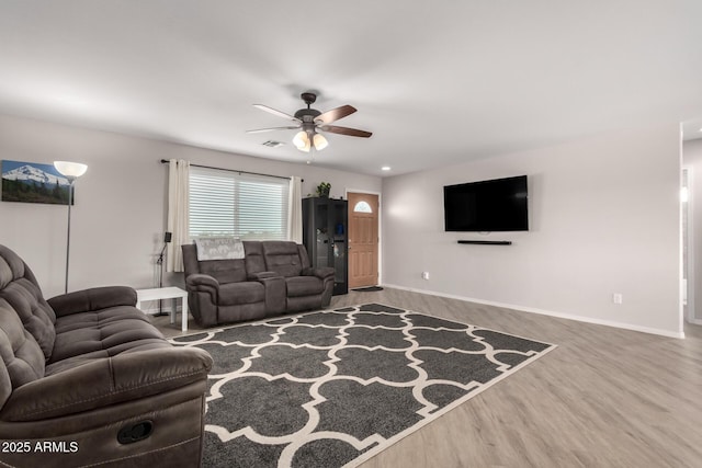 living area featuring ceiling fan, wood finished floors, visible vents, and baseboards