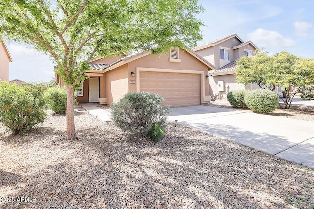 view of front of house featuring a tiled roof, a garage, driveway, and stucco siding