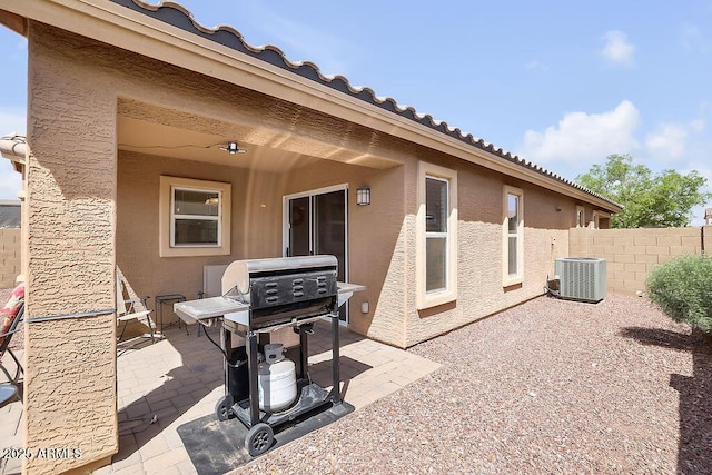 view of patio featuring central air condition unit, a grill, and fence