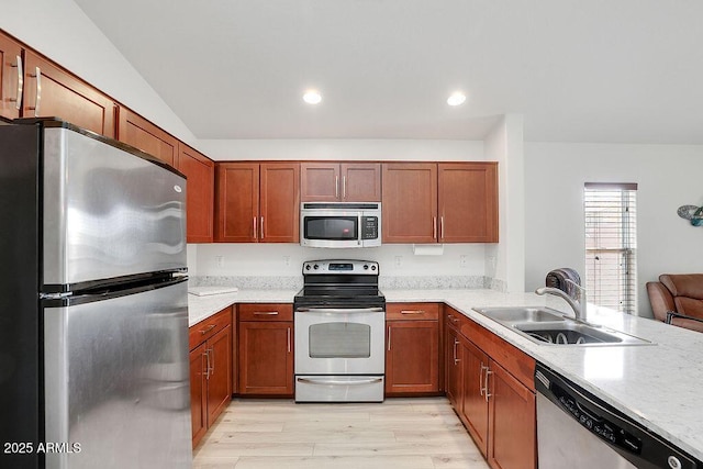kitchen with light wood-style floors, recessed lighting, a sink, stainless steel appliances, and brown cabinets