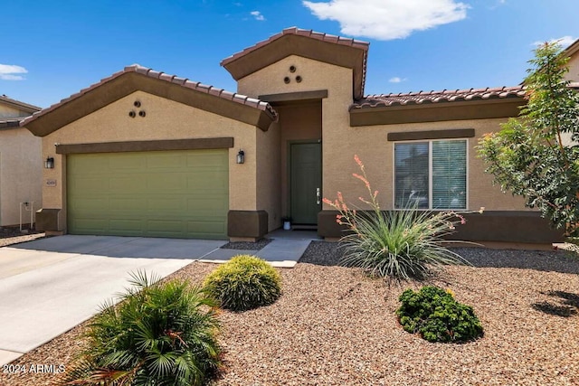 mediterranean / spanish house with a garage, concrete driveway, and stucco siding