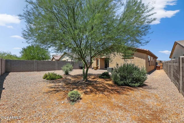 view of yard with a fenced backyard and central AC unit