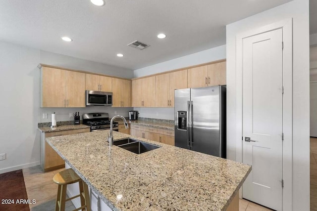 kitchen with visible vents, stainless steel appliances, a sink, and light brown cabinetry