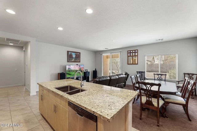 kitchen with a sink, light stone countertops, visible vents, and dishwasher