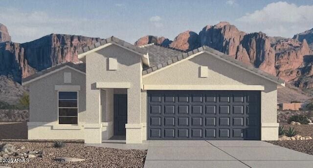 view of front of house featuring a garage, a mountain view, and stucco siding