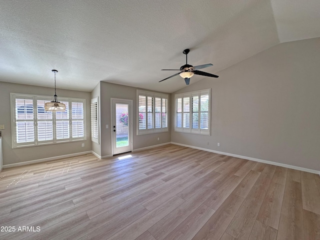 8319 E Plata Ave, Mesa, AZ 85212 - unfurnished living room featuring vaulted ceiling, a ceiling fan, light wood-style floors, baseboards, and a textured ceiling
