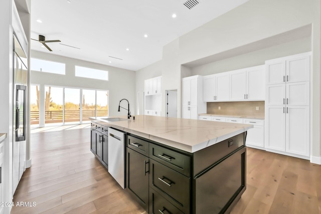 kitchen featuring light stone countertops, white cabinets, and light hardwood / wood-style flooring