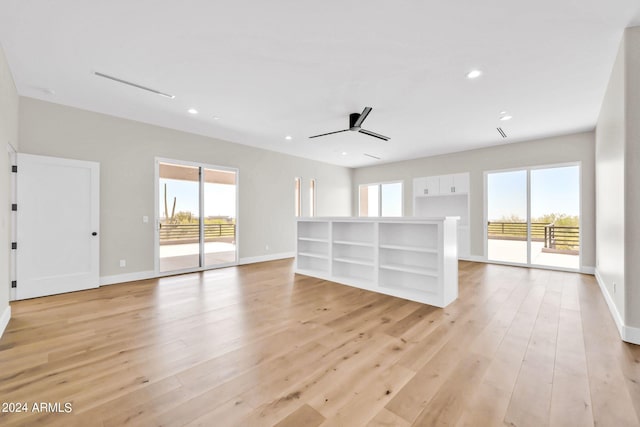 unfurnished living room with a wealth of natural light, ceiling fan, and light wood-type flooring