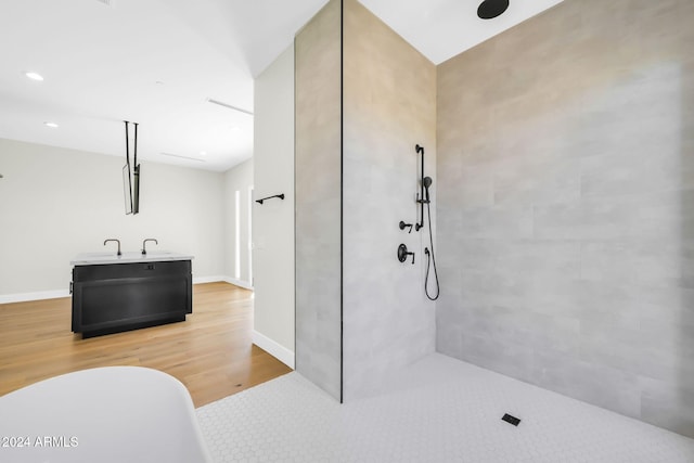 bathroom featuring tiled shower, vanity, and hardwood / wood-style floors