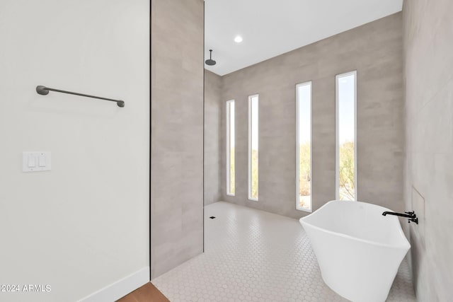 bathroom featuring tile walls, plus walk in shower, and tile patterned floors