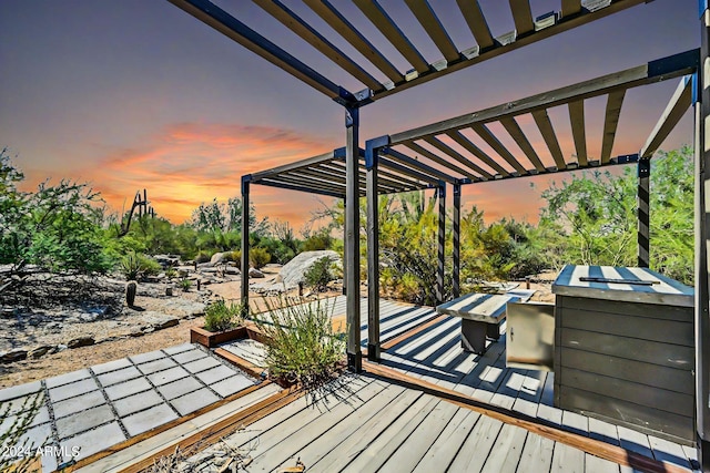 deck at dusk with a pergola and an outdoor kitchen