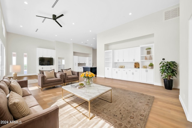 living room with ceiling fan and light hardwood / wood-style floors