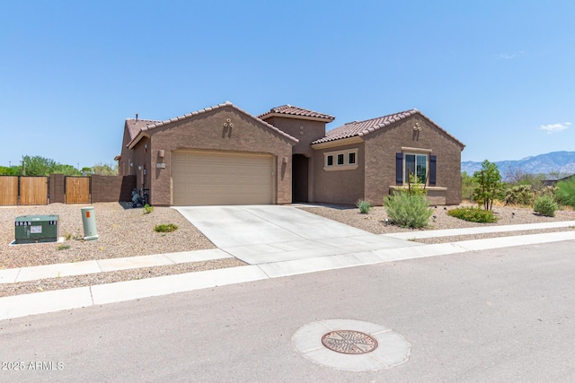 view of front of house featuring a gate, driveway, stucco siding, a garage, and a tile roof