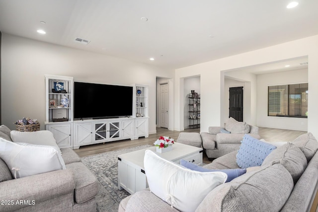 living area featuring light wood-style flooring, recessed lighting, and visible vents