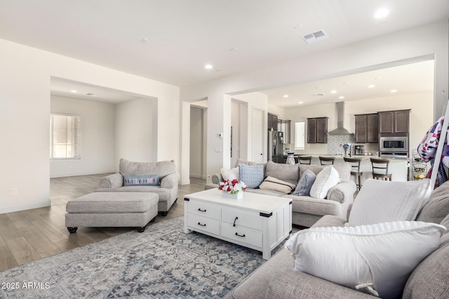 living room featuring visible vents, recessed lighting, light wood-type flooring, and baseboards