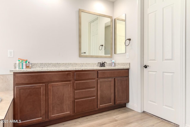 full bathroom featuring vanity and wood finished floors