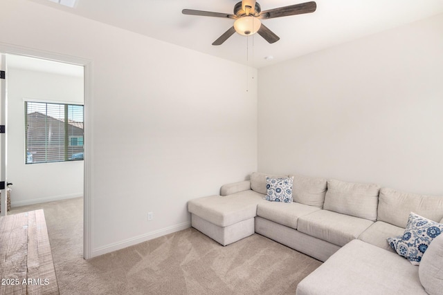 living room with light carpet, baseboards, and ceiling fan