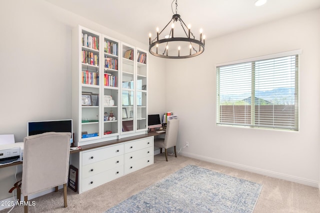 carpeted office space featuring baseboards and a notable chandelier