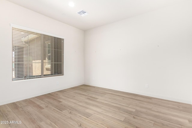 spare room with visible vents, baseboards, and light wood-style floors