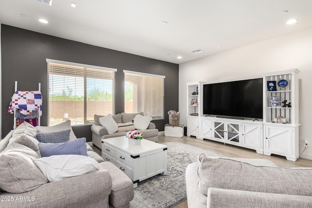 living room with visible vents, recessed lighting, and light wood-type flooring