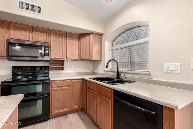 10209 W Jessie Ln, Peoria, AZ 85383 - kitchen featuring black appliances, vaulted ceiling, a sink, light countertops, and light wood-style flooring