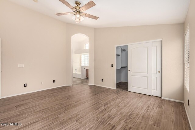 10209 W Jessie Ln, Peoria, AZ 85383 - unfurnished bedroom with arched walkways, wood finished floors, baseboards, and ensuite bathroom