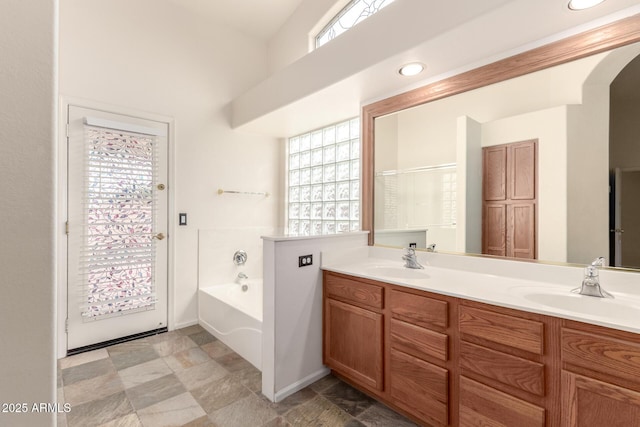 10209 W Jessie Ln, Peoria, AZ 85383 - full bathroom featuring stone finish flooring, a bath, double vanity, and baseboards