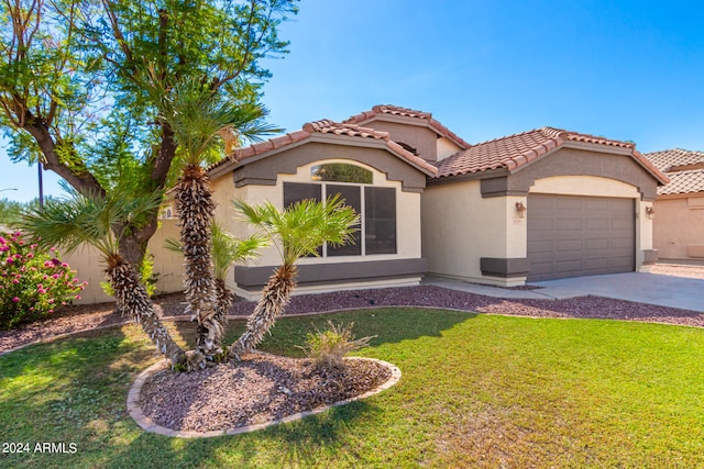 mediterranean / spanish home featuring a garage and a front lawn