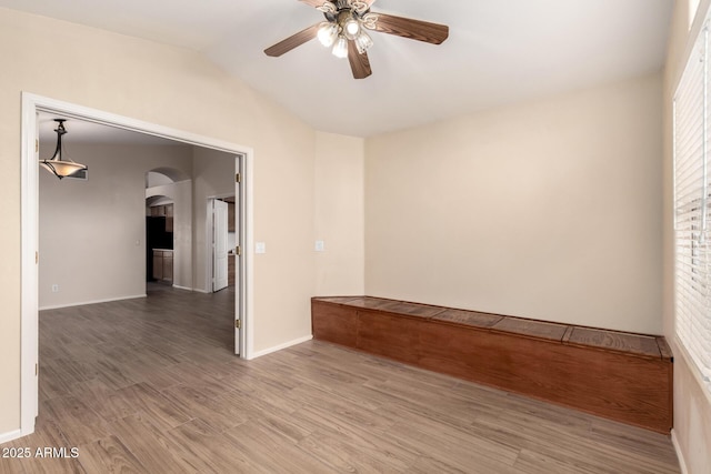 10209 W Jessie Ln, Peoria, AZ 85383 - spare room featuring arched walkways, ceiling fan, vaulted ceiling, light wood-type flooring, and baseboards