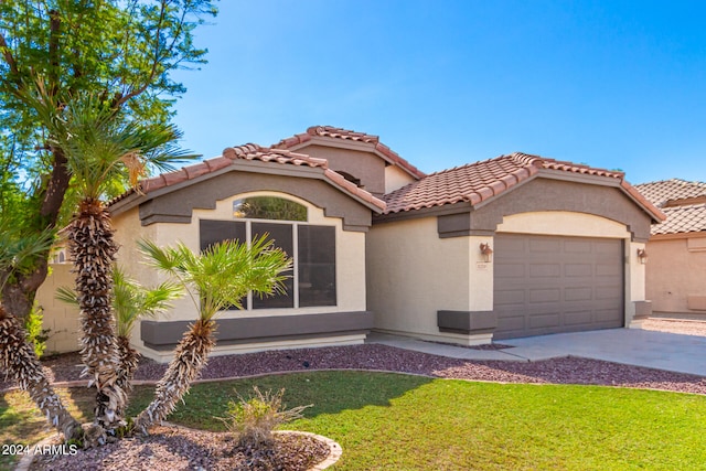 mediterranean / spanish-style home with a garage and a front yard