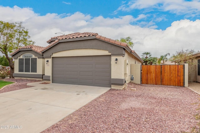 10209 W Jessie Ln, Peoria, AZ 85383 - mediterranean / spanish house featuring a tile roof, a gate, driveway, stucco siding, and an attached garage