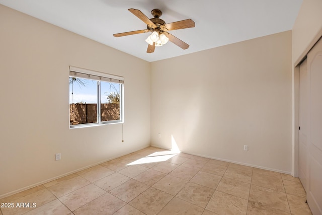 unfurnished room featuring light tile patterned floors, ceiling fan, and baseboards