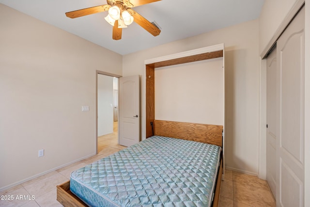 bedroom featuring a closet, light tile patterned flooring, and baseboards