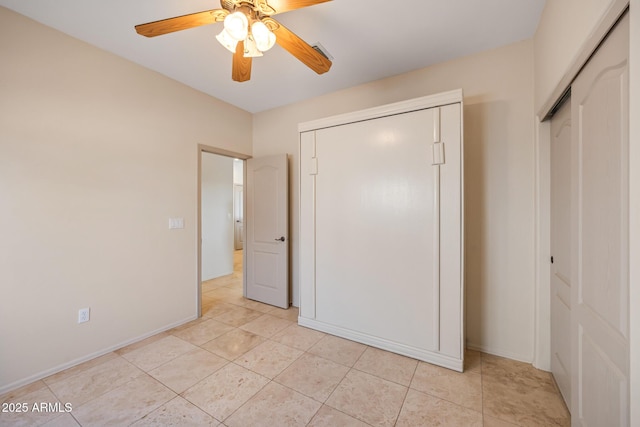 unfurnished bedroom with ceiling fan, baseboards, and light tile patterned flooring