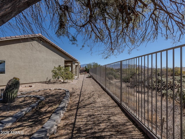 view of side of home featuring fence and stucco siding