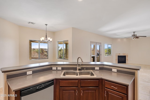 kitchen featuring a glass covered fireplace, open floor plan, a sink, dark brown cabinets, and dishwasher