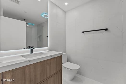 full bathroom featuring a shower, visible vents, toilet, and vanity