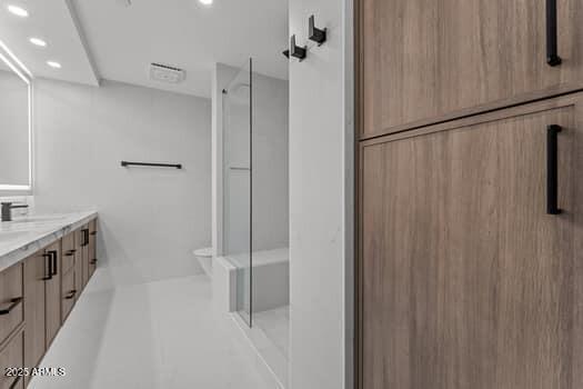 bathroom with recessed lighting, vanity, and a shower stall