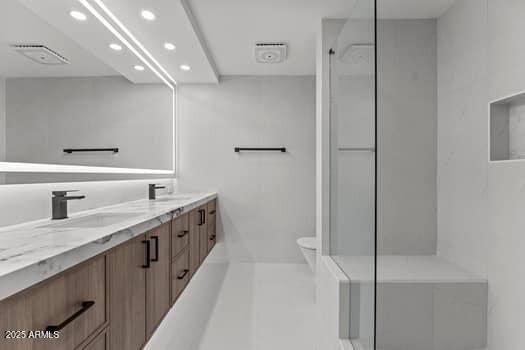 bathroom with a sink, recessed lighting, double vanity, and a walk in shower