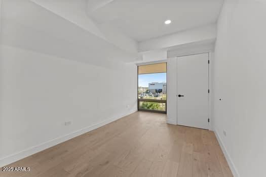 unfurnished room featuring recessed lighting, light wood-style floors, and baseboards