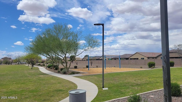 view of community with fence, playground community, a residential view, and a lawn