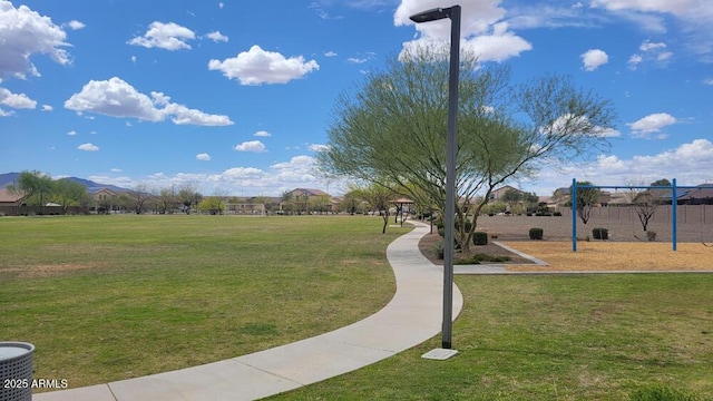 view of home's community featuring a lawn and playground community