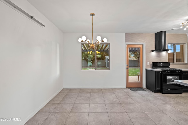 kitchen with wall chimney exhaust hood, gas stove, an inviting chandelier, hanging light fixtures, and light tile patterned floors